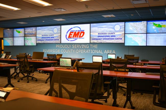 Photo showing the County of Riverside Emergency Operations Center with numerous displays showing logos and data related to disaster preparedness.