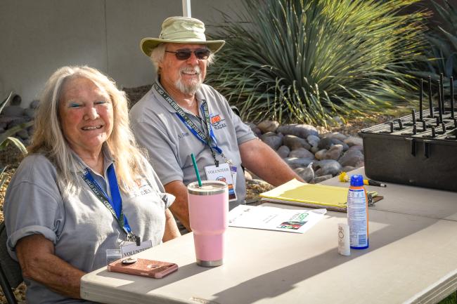 RACES volunteers in grey polo shirts sit at a desk.