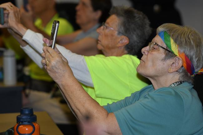 Attendees hold up their phone cameras to scan a QR code.