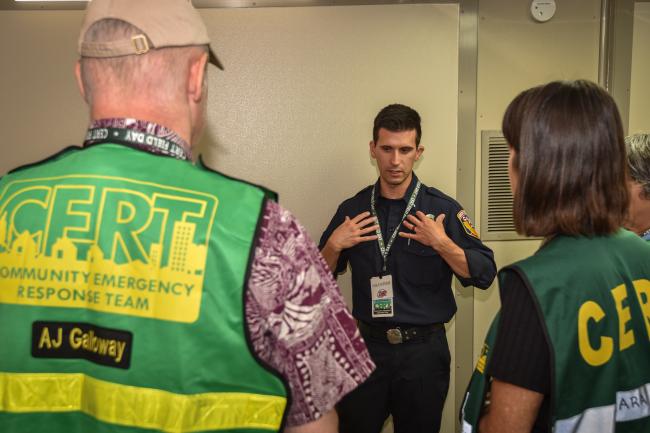 A man in a CAL FIRE uniform talks with CERT members.