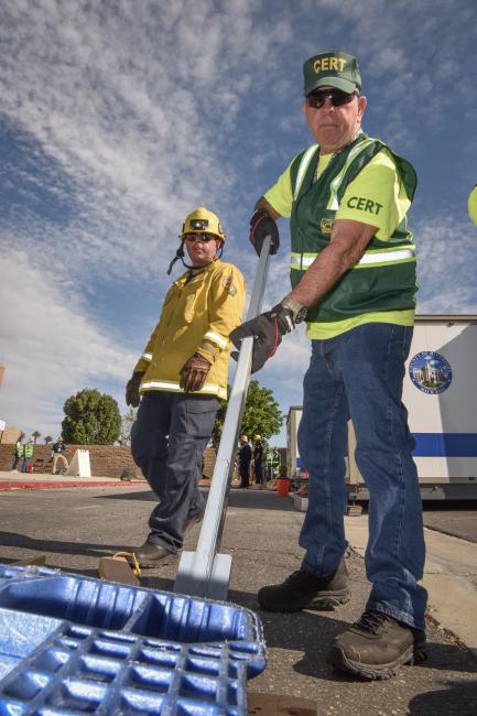 CERT members use a leverage tool to lift a heavy object.