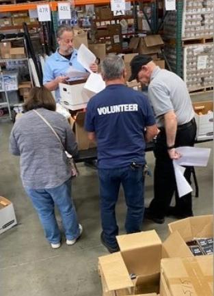 Four people in a warehouse.